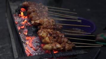 The process of making Indonesian chicken satay in traditional way using charcoal. video
