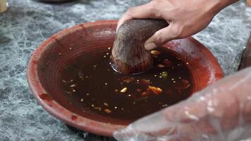 Traditional Indonesian sauce named sambal bawang in the making using traditional tool. video