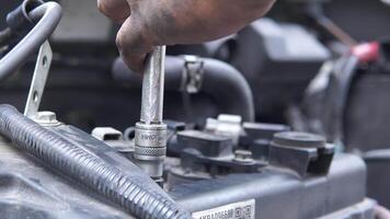 A man is working on a car engine with a socket wrench. video