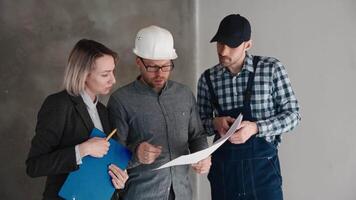 Meeting at the construction site. An engineer, a builder and a female architect are discussing the design of a new house. Construction professionals at work video