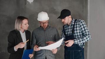 Meeting at the construction site. An engineer, a builder and a female architect are discussing the design of a new house. Construction professionals at work video