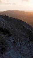 A man is standing on top of a hill at sunset video