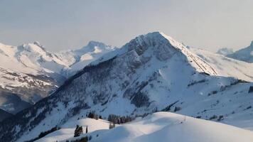 A snow covered mountain range with a person on a snowboard video
