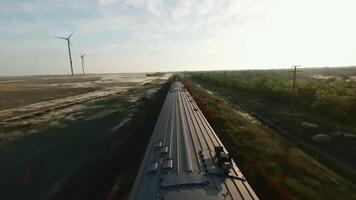 Experience a Scenic Train Journey Through Majestic Wind Farms and Beautiful Fields of Nature. Media video