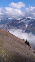 berg räckvidd i moln på blå himmel bakgrund. klämma. se från de berg topp på Fantastisk ändlös hög kullar och vit strömmande moln, skönhet av natur. video