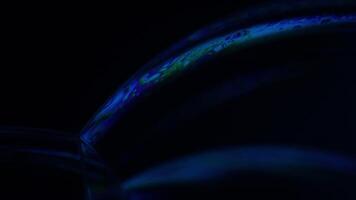 Bright rainbow reflection of liquid in macro, dark background, surrealistic background, fantastic smooth movement video