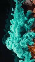 Splash of colored ink in water on black background. Action. Two colors are mixed in water on isolated background. Close-up of colored ink beautifully submerged in water in slowmo video