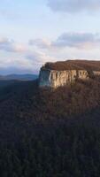 Beautiful mountain panorama with rock and cross. Shot. Top view of sacred rock with cross on background of green mountains. Sun shines on single rock with cross video
