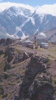 Top view of mountain pass with Observatory on background of snow peaks. Clip. Old Observatory is located in mountains with view of snow-capped mountains. Beautiful mountain landscape video