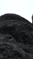 Giant rocks on cloudy sky background. Clip. Close up of grey stone texture. video