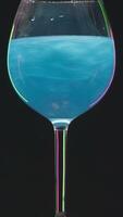 Drink shimmers in a glass on isolated background. Stock footage. Beautiful alcoholic drink with sequins in transparent glass on isolated background. Magic colored drink is poured in glass video