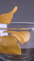 Chips falling on isolated background. Stock footage. Delicious chips fall and cause appetite. Harmful snacks in form of potato chips. Favorite junk food video