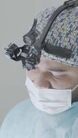 Surgeon in binoculars. Action. Young professional surgeon is preparing for operation. Surgeon prepares for operation, washes hands and prepares place video
