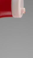 Ketchup being squeezed out of bottle. Stock footage. Close-up of jet of red ketchup on gray background. Ketchup spills out of large red bottle video