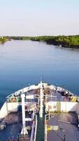 Top view of bow of cargo ship floating on river. Footage. Bow of ship is rapidly moving forward on river on background horizon. Cargo ship sails along beautiful river that reflects sky video