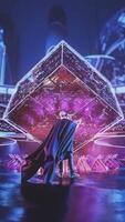 Abstract arena lit up by neon light with an energy giant 3D cube in the middle and a superhero with a fluttering cloak. Stock footage. Beginning of the fight or the show and people with superpowers. video