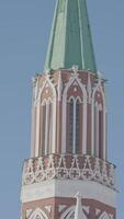 Nikolskaya tower of Moscow kremlin. Action. Bottom view of historic red brick tower on background of blue sky. Beautiful tower on Red Square in Russia video
