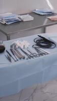 A table with surgical sterile instruments, scalpels and clamps. Action. Details of the operating room, prepared clean medical instruments, devices for a surgery and a bowl with iodine. video