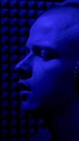 Man singing In recording studio with microphone. HDR. Side view of a young male singer recording a song in a music dark studio with blue light. video