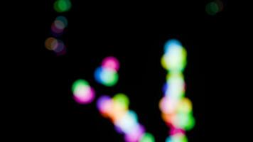 Abstract colored bokeh circles on a black background in a seamless loop. video