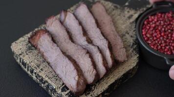 Grilled wagyu beef tomahawk steak with salt, spices and herbs on a dark concrete background video
