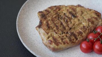 Grilled beef or pork steak with salt, spices and herbs on a dark concrete background video