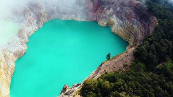 Experience the mesmerizing of Kelimutu's Three Color Lake in Ende. Wrapped in mystical clouds, this magical site, rich in legend, offers a breathtaking landscape that captivates the soul. video