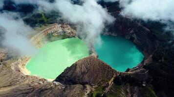 Experience the mesmerizing of Kelimutu's Three Color Lake in Ende. Wrapped in mystical clouds, this magical site, rich in legend, offers a breathtaking landscape that captivates the soul. video