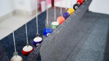 Newton's cradle showing laws of physics in motion. Museum of Science video