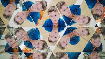 Curious boy in blue and yellow shirt reflecting in the mirrors of kaleidoscope. Abstract montage of a child in many triangle parts of the kaleidoscope. video