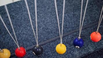 Newton's cradle showing laws of physics in motion. Museum of Science video