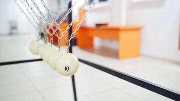 Newton's cradle showing laws of physics in motion. Museum of Science video