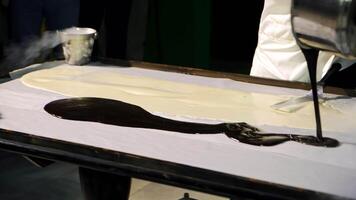 Chief cook makes delicious black and white ice-cream on a big table. Modern preparation of ice-cream on the white surface with liquid nitrogen. video