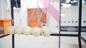 Newton's cradle showing laws of physics in motion. Museum of Science video