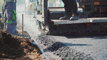 Asphalt paver machine laying hot asphalt to the road and workers control. Spillage of asphalt on the highway. Fresh asphalt resurfacing the street. New service of technology asphalting. video