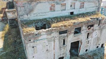 Front side of abandoned building exterior without doors and windows. Ruined plant after military actions. Aerial view. video