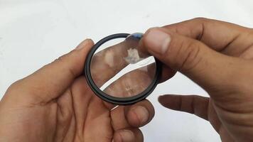 Two lenses of large and small size are shown to someone. The magnifying glass of the camera video