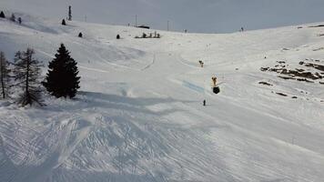 Ski slopes, tranquility between the snow and the mountains. Aerial shot backwards passing between 2 pine trees. Brocon Pass, Trentino video