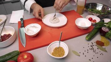 Cook puts sour cream and white tartar sauce on plate, which is intended to be served in an expensive restaurant. This gives dish complete look, suitable for serving in an expensive restaurant. video