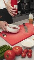 Chef generously pours raw salted beef for tartare with an appetizing honey-mustard dressing, and then mixes it with spoon in deep dish in restaurant kitchen. video