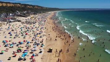 Aerial view of crowded beach in Costa de Caparica with lifeguard vehicle video