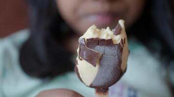 A Child Happily Enjoying a Delicious ChocolateCovered Ice Cream Bar on a Warm Day video