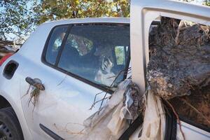 VALENCIA, SPAIN OCTOBER 31, 2024. Mud and debris cover a car damaged by flooding in Valencia, highlighting the devastating impact of the natural disaster photo