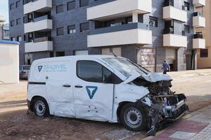 VALENCIA, SPAIN OCTOBER 31, 2024. Devastating consequences of flooding in Valencia, Spain, featuring a damaged white van parked on the street with visible debris photo
