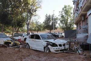 VALENCIA, SPAIN OCTOBER 31, 2024. A damaged car sits covered in mud in the aftermath of a devastating flood in Valencia, Spain, highlighting the destructive power of nature photo