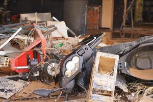 VALENCIA, SPAIN OCTOBER 31, 2024. Scooter handlebars and other debris piling up inside a building in Valencia after severe flooding photo