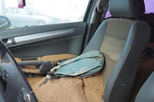 VALENCIA, SPAIN OCTOBER 31, 2024. Interior of a car filled with mud and debris after devastating floods in Valencia, highlighting a backpack resting on the seat photo