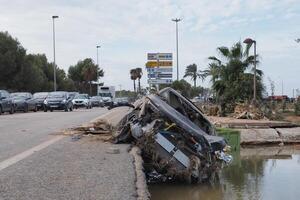 VALENCIA, SPAIN OCTOBER 31, 2024. Devastating consequences of flooding showing destroyed car lying on roadside in Valencia, Spain photo