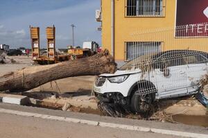 VALENCIA, SPAIN OCTOBER 31, 2024. Devastating consequences of flooding in Valencia, with a large tree resting on a damaged car photo