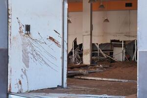 VALENCIA, SPAIN OCTOBER 31, 2024. Interior of a destroyed commercial building in Valencia, filled with mud and debris after a devastating flood photo